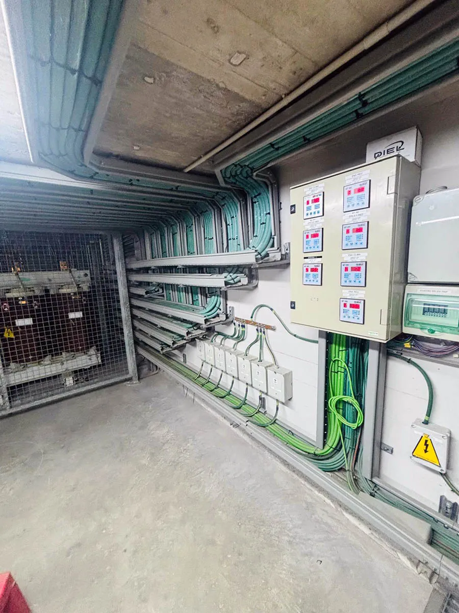 Interior de centro de transformación con bandejas de cables verdes, conducciones y cuadro de control DIER con protecciones digitales