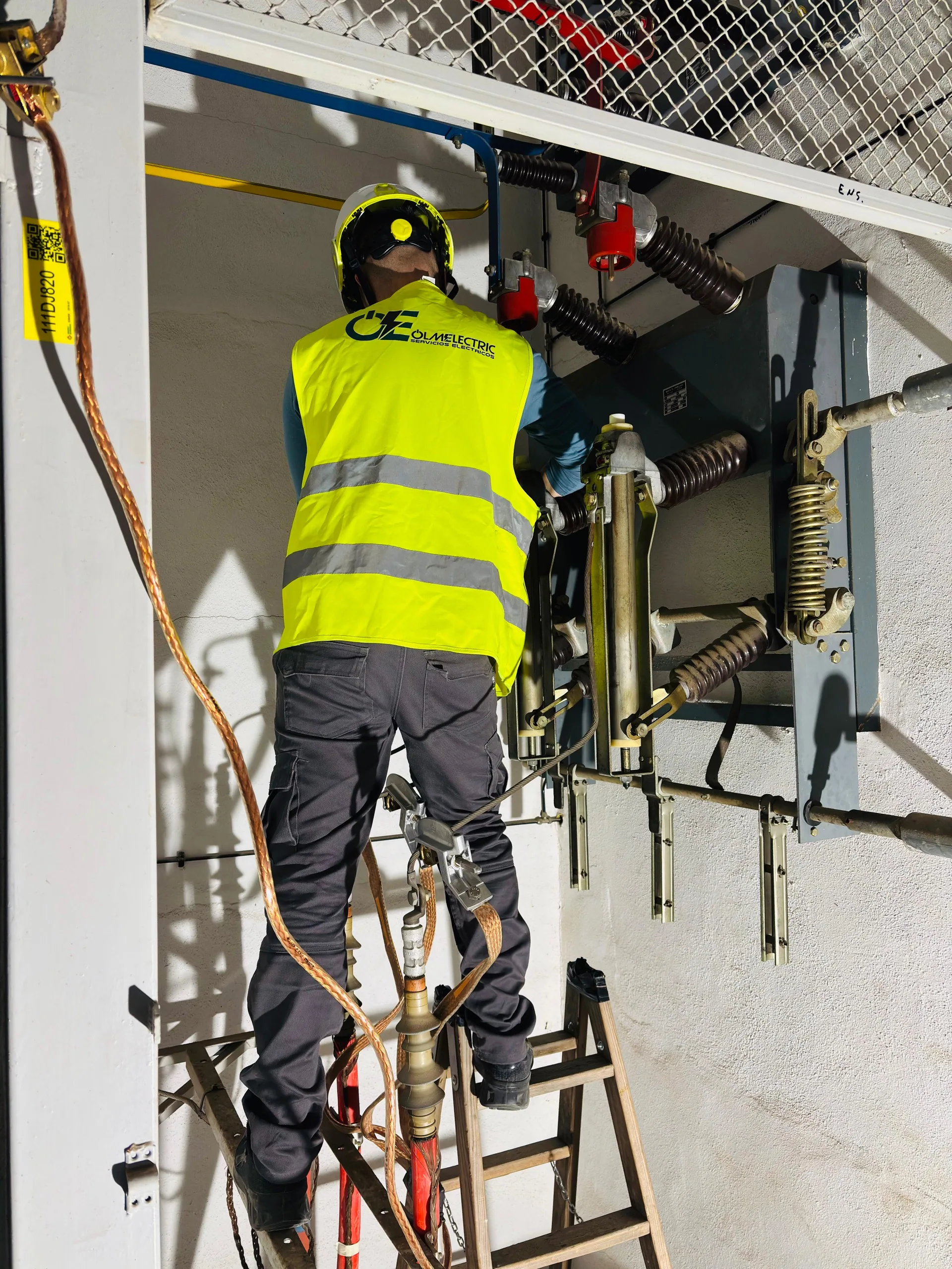 Instalador eléctrico de OLMELECTRIC trabajando en celda de alta tensión con seccionadores