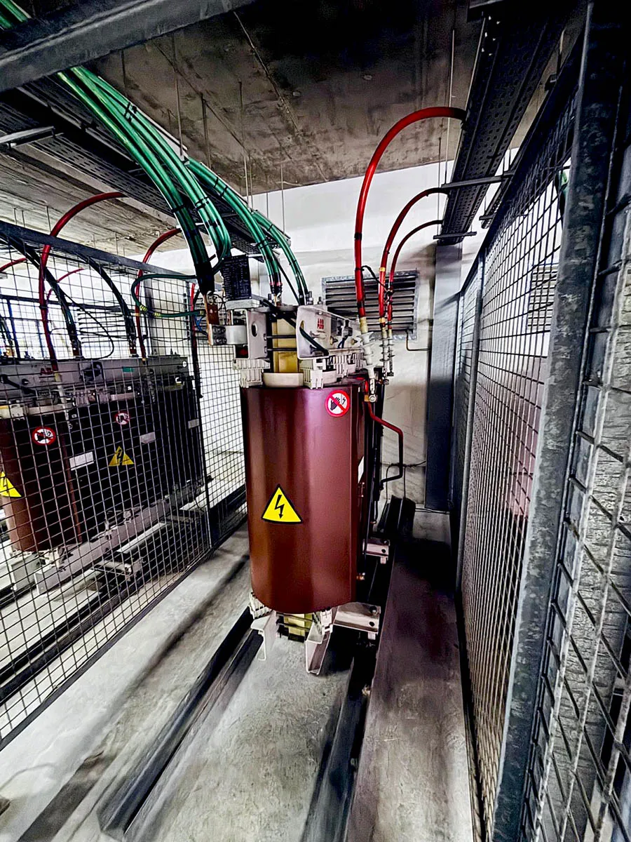 Transformador seco trifásico ABB en celda de media tensión con conductores de alta tensión en rojo y verde en centro de transformación